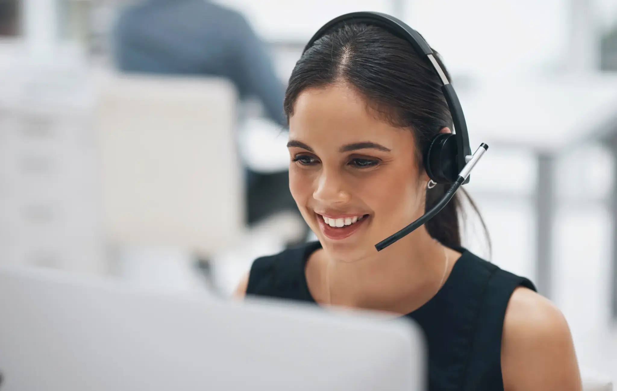 Freundliche Dienstleisterin mit Headset im Kundengespräch
