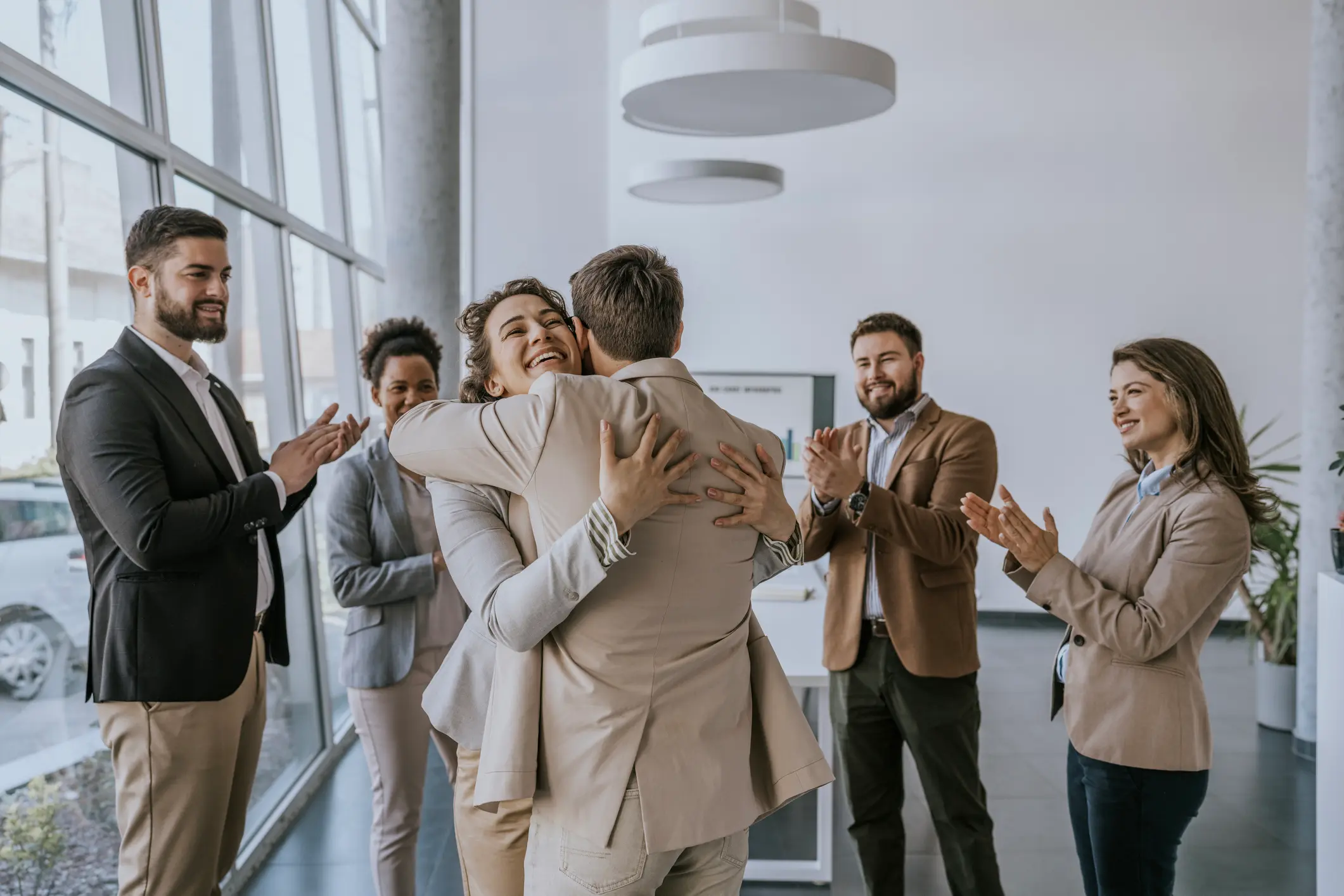 Kollegen gratulieren einem Mitarbeitenden herzlich – symbolisch für Wertschätzung durch betriebliche Altersversorgung