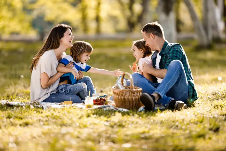 Familie bei einem Picknick im Grünen – zeigt Zusammenhalt, Lebensfreude und die Bedeutung finanzieller Absicherung