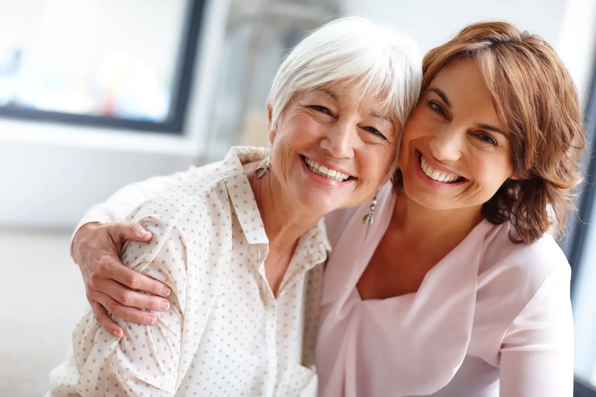 Zwei Frauen unterschiedlichen Alters lachen und umarmen sich – Symbolbild für generationenübergreifende Vorsorge mit Altersrückstellungen.