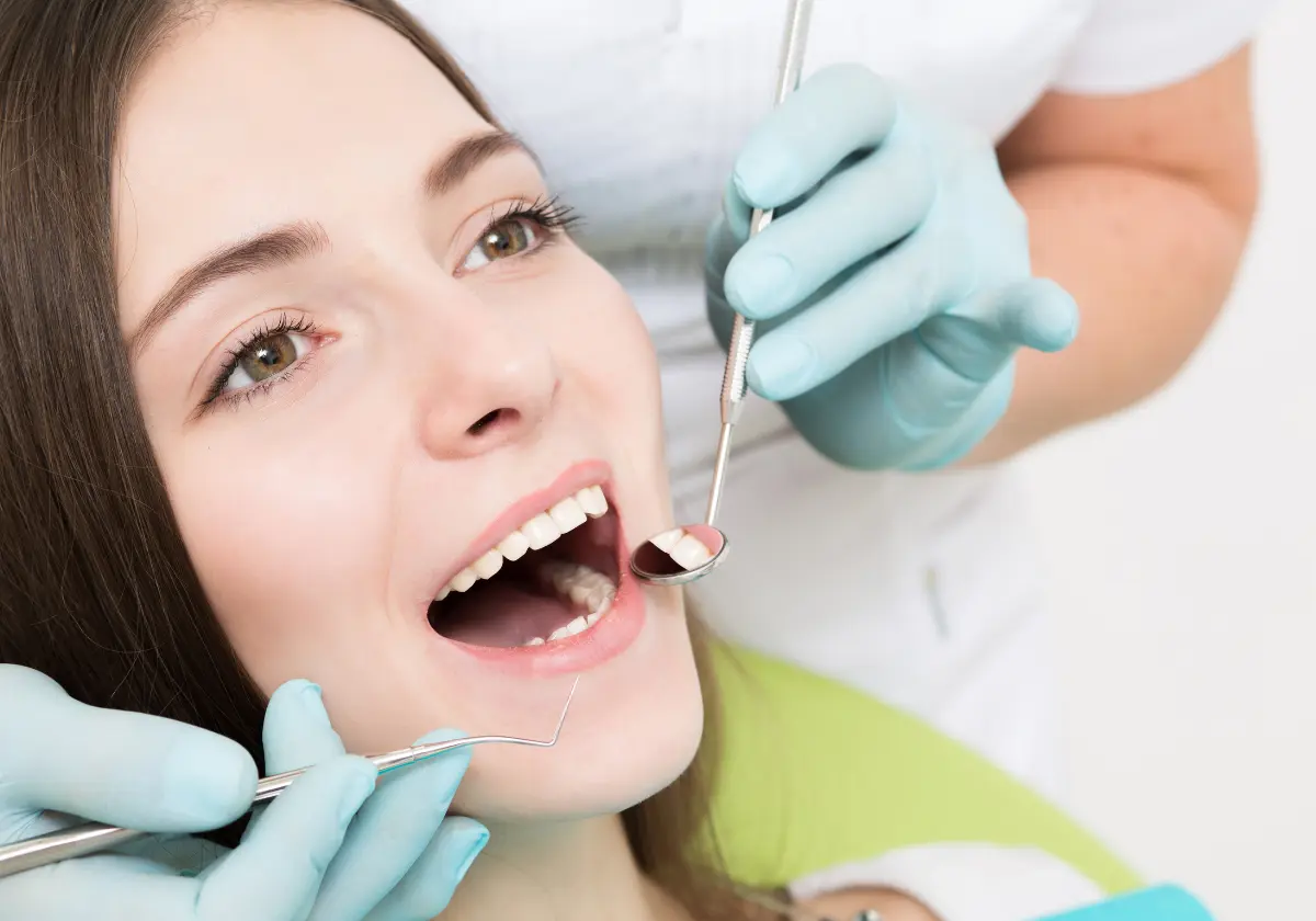 Zahnärztliche Behandlung einer Frau bei geöffneter Mundhöhle in moderner Praxis