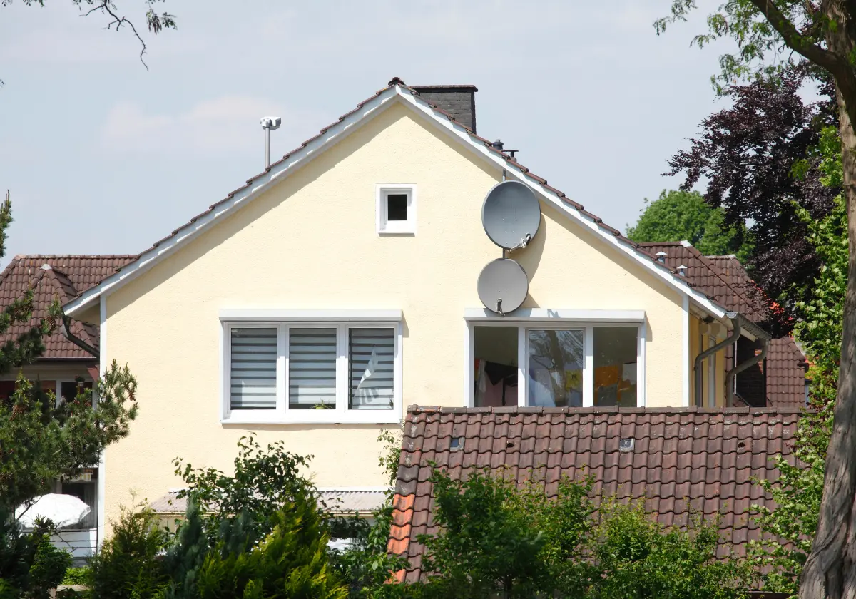 Zwei Etagen hohes Einfamilienhaus mit Satellitenschüssel und gepflegtem Garten
