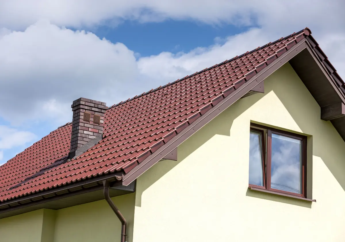 Gelbes Einfamilienhaus mit Satteldach und braunen Fensterläden