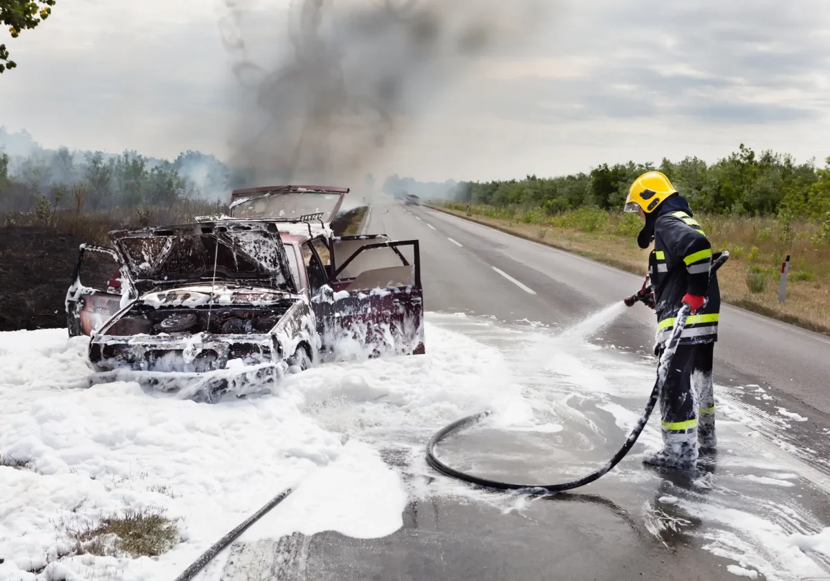 Autobrand Feuerwehr löscht brennendes Auto auf Landstraße – Symbolbild für Autobrand und Kfz-Versicherung bei Totalschaden