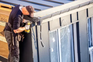 Handwerker bei Montagearbeiten an einem Haus – Symbolbild für betriebliche Haftung und Betriebshaftpflichtversicherung