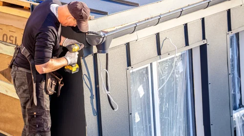 Handwerker bei Montagearbeiten an einem Haus – Symbolbild für betriebliche Haftung und Betriebshaftpflichtversicherung