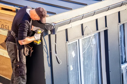 Handwerker bei Montagearbeiten an einem Haus – Symbolbild für betriebliche Haftung und Betriebshaftpflichtversicherung