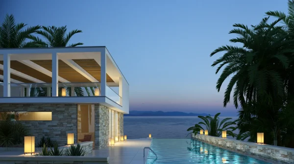 Modernes Ferienhaus mit Pool und Meerblick bei Sonnenuntergang, umgeben von Palmen und stimmungsvoller Beleuchtung