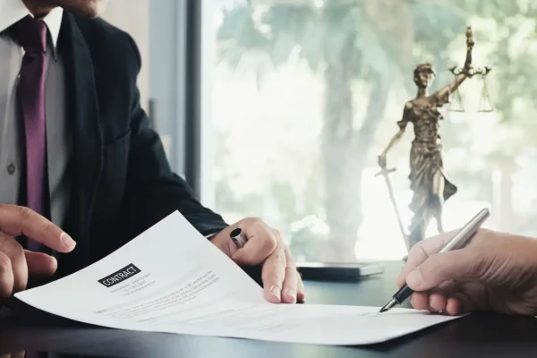 Zwei Personen unterzeichnen einen Vertrag in einem Büro