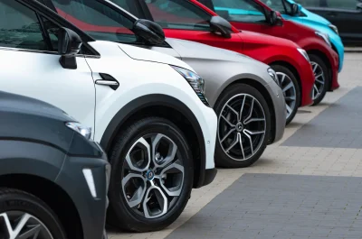 Reihe moderner Firmenfahrzeuge auf einem Parkplatz – Symbolbild für gewerblichen Fuhrpark und passende Versicherungslösungen