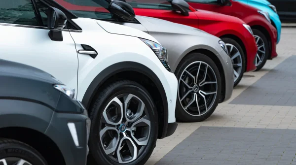 Reihe moderner Firmenfahrzeuge auf einem Parkplatz – Symbolbild für gewerblichen Fuhrpark und passende Versicherungslösungen