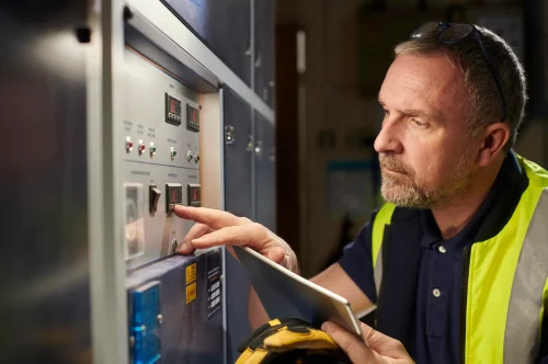 Techniker überprüft eine industrielle Steuerungseinheit – Sicherheit und Verantwortung bei Produkten im Fokus