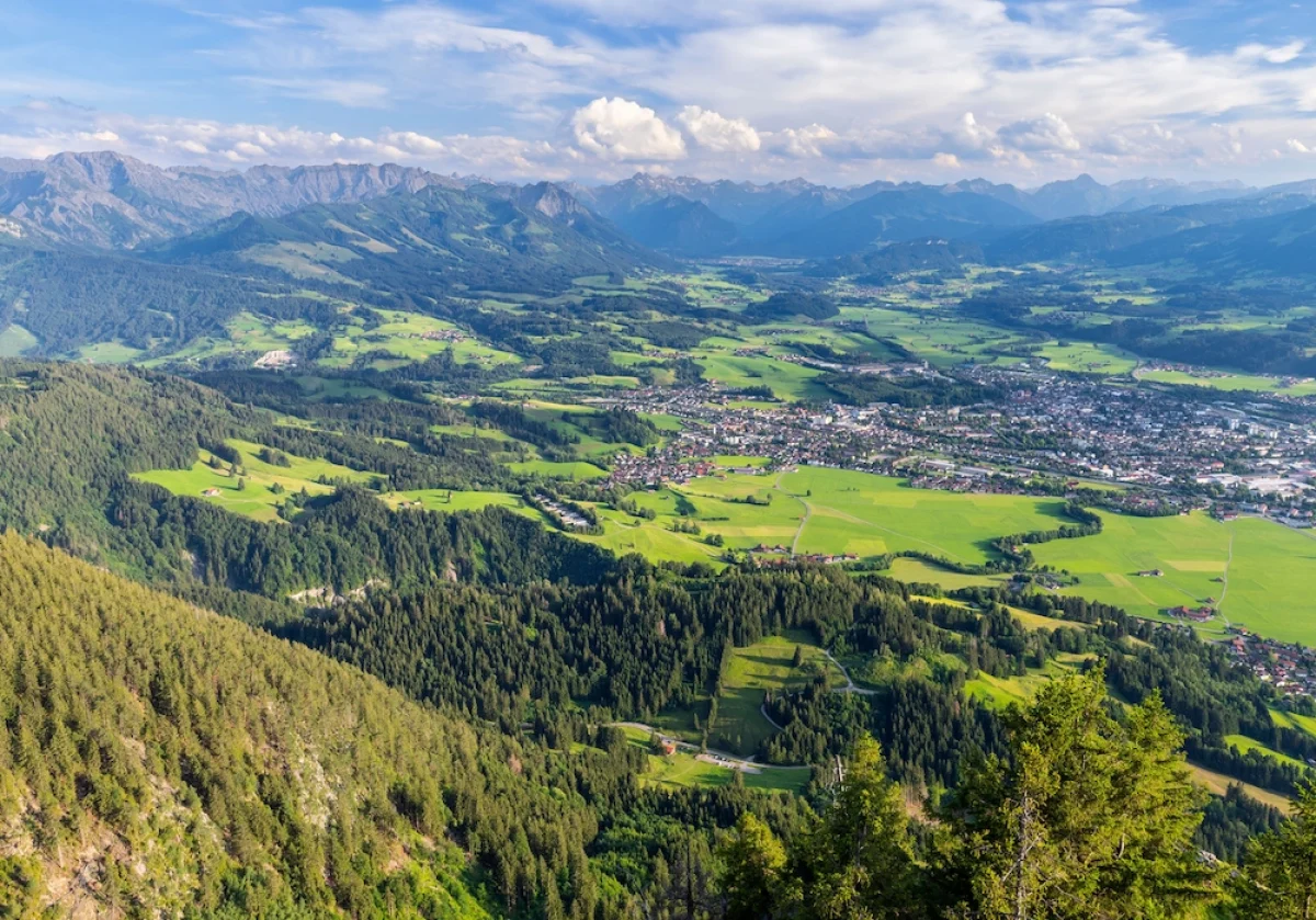 Versicherungsmakler Sonthofen Blick vom Berg auf Sonthofen im Illertal mit weiten Wiesen und Wäldern – Einzuggebiet des AMBA Versicherungsmaklers im Allgäu