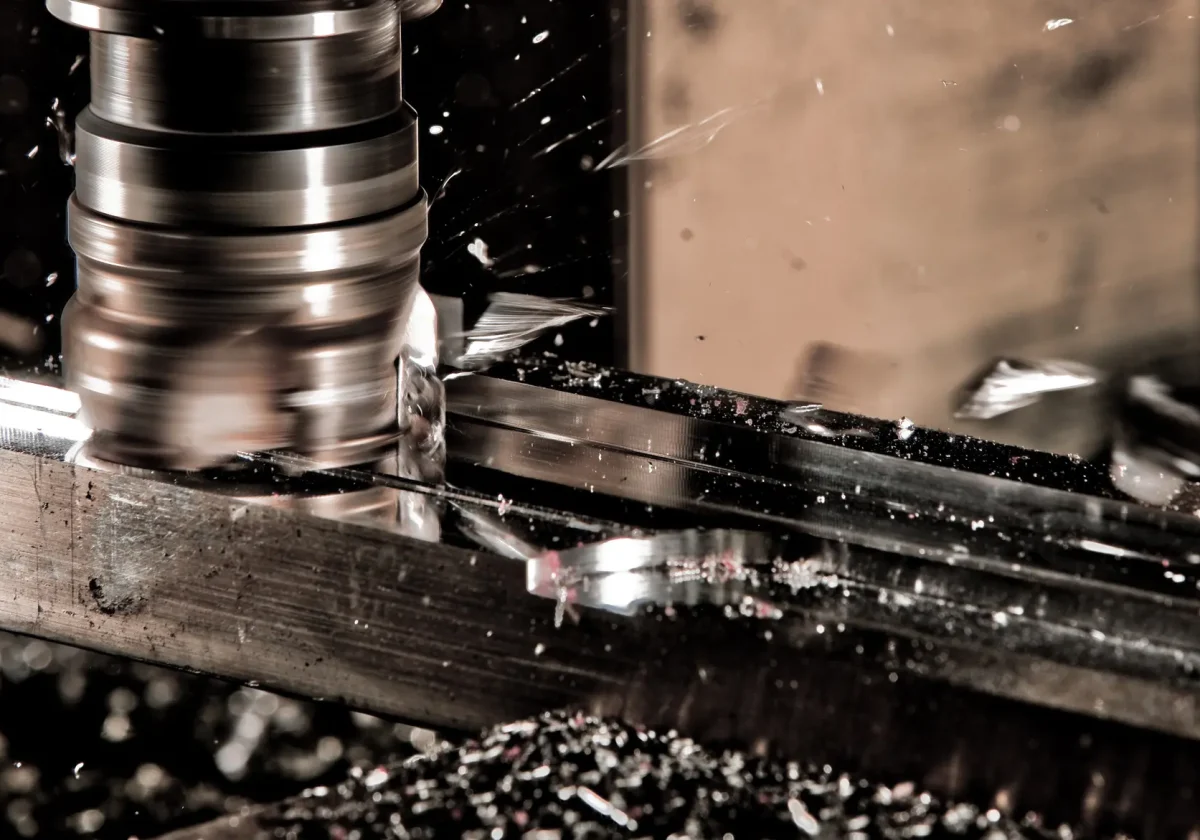 Nahaufnahme einer CNC-Fräse bei der Metallbearbeitung mit Funkenflug – Symbolbild für Technikversicherung in der Industrie