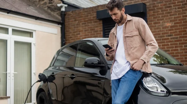 Mann lädt E-Auto an Wallbox vor Mietwohnung
