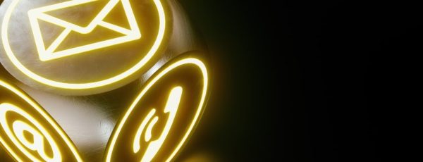 Leuchtender Würfel mit Symbolen für E-Mail, Telefon und Internet auf dunklem Hintergrund