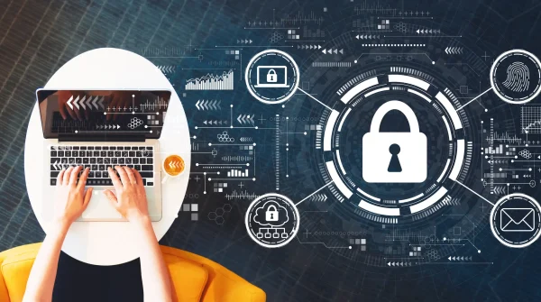 Person arbeitet am Laptop, daneben Symbole für Datenschutz und Sicherheit – steht sinnbildlich für anonyme Risikovoranfrage zur BU-Versicherung