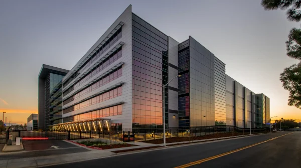 Modernes Firmengebäude bei Sonnenuntergang – Symbolbild für gewerbliche Immobilien und Firmengebäudeversicherungen