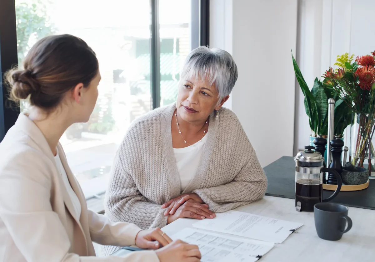 Ältere Frau im Gespräch mit Beraterin am Tisch – Symbolbild zur gesetzlichen Rentenversicherung und Beratung im Alter