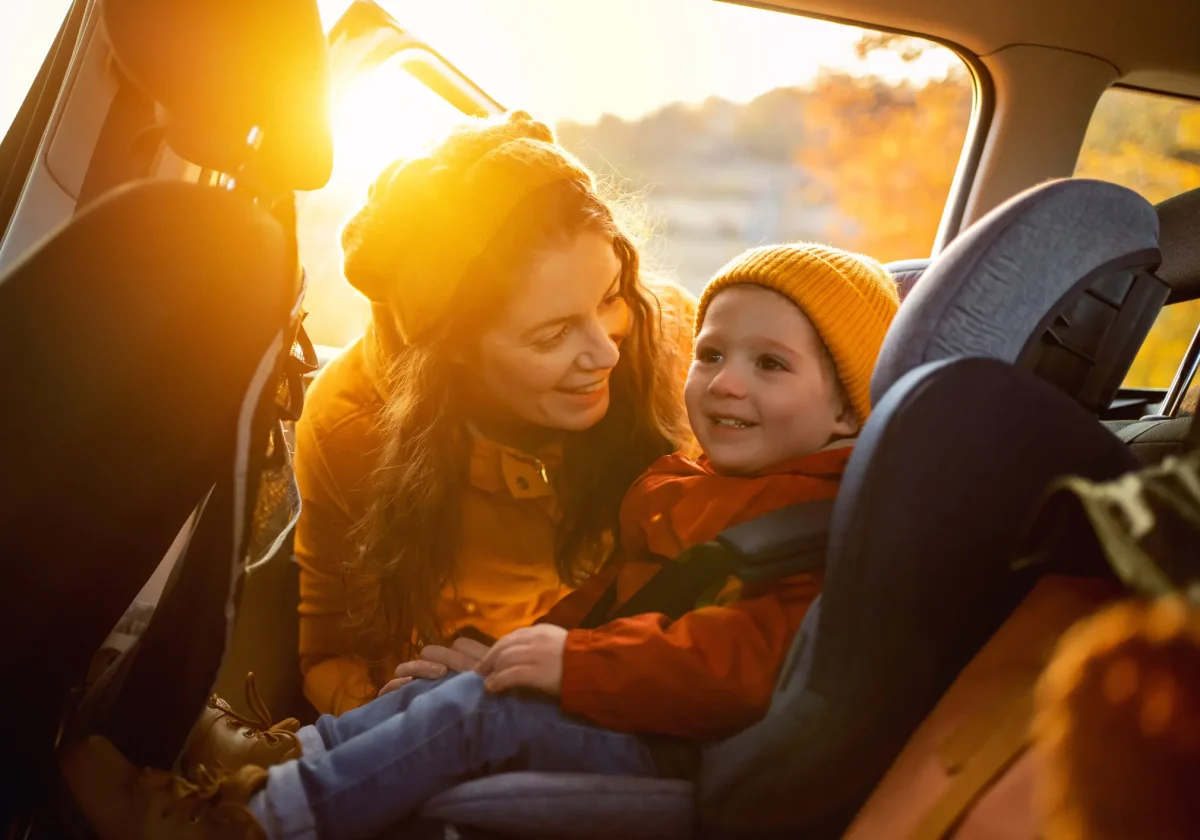 Mutter sichert ihr Kind im Kindersitz auf dem Rücksitz eines Autos – Symbolbild für Sicherheit und Verantwortung im Straßenverkehr